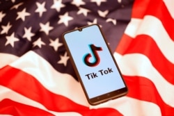 Tik Tok logo is displayed on the smartphone while standing on the U.S. flag in this illustration picture taken, Nov. 8, 2019.