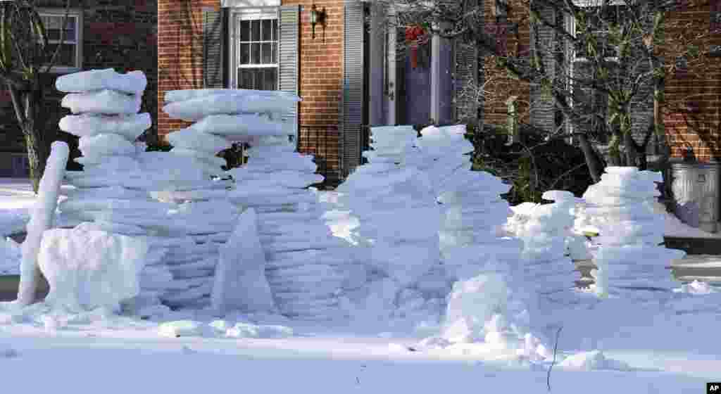 Stacks of icy snow are piled up outside a home after it was removed from a driveway in Cincinnati, Ohio, Feb. 12, 2014.