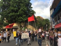 Protesters march down the main street of downtown Medellín, Colombia on Sept. 11, 2020. Soon after, they clashed with police. (Megan Janetsky/VOA)