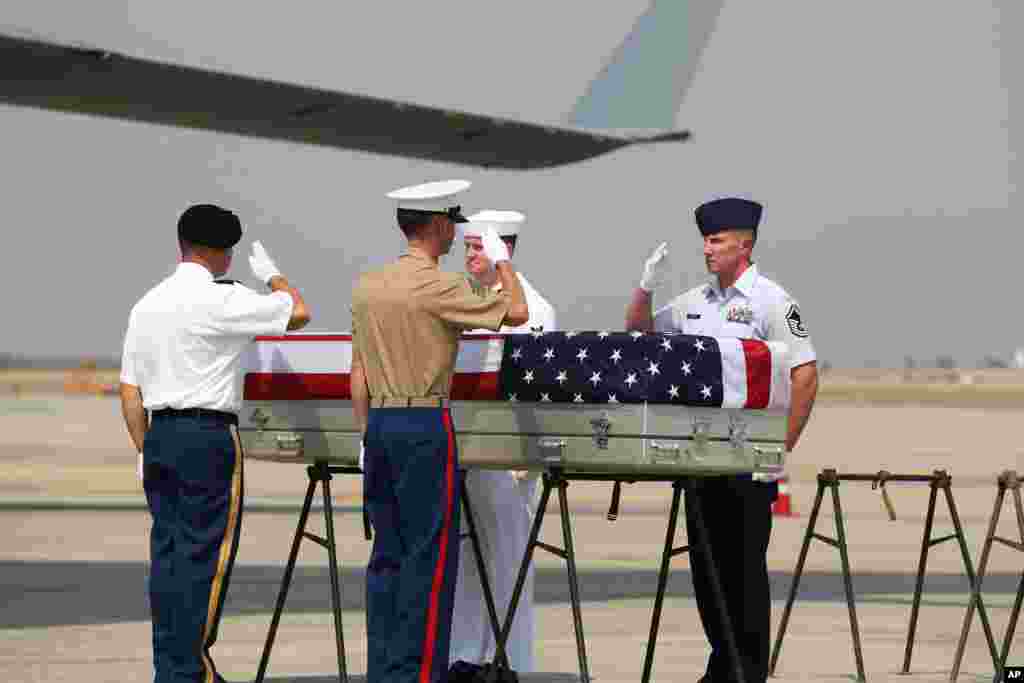 U.S. military guard of honor salute a coffin during a repatriation ceremony at Mandalay International Airport in central Myanmar. The U.S. military has repatriated what may be the remains of service personnel who were lost in action during World War II.