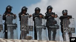 National Guard troops equipped with riot gear stand guard at Las Pilas dam, two days after withdrawing from the nearby La Boquilla dam after clashing with hundreds of farmers, in Camargo, Chihuahua State, Mexico, Sept. 10, 2020. 