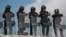 National Guard troops equipped with riot gear stand guard at Las Pilas dam, two days after withdrawing from the nearby La Boquilla dam after clashing with hundreds of farmers, in Camargo, Chihuahua State, Mexico, Sept. 10, 2020. 