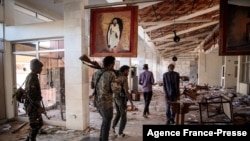 Amhara Fano militia fighters walk in the ransacked terminal at the Lalibela airport in Lalibela, Ethiopia, Dec. 7, 2021.