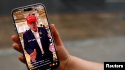 Žena pozira sa svojim pametnim telefonom prikazujući @ realdonaldtrump TikTok stranicu, Vašington, 19. januar, 2025. (Foto: REUTERS/Shannon Stapleton)