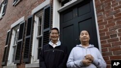 New U.S. citizens Pay Reh, left, and Poe Meh, originally from Myanmar, also known as Burma, stand for a photograph at the entrance to their home, in Lowell, Massachusetts, May 20, 2020. Both were among those granted a special oath ceremony last week.