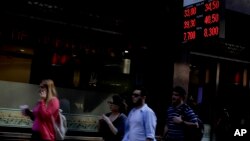 People walk by a currency exchange office in Buenos Aires, Argentina, Aug. 29, 2018.