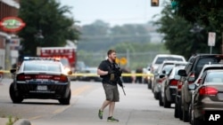 Polisi menyusuri area serangan terhadap markas polisi yang dilakukan oleh pria bersenjata di Dallas, Texas, 13 Juni 2015.