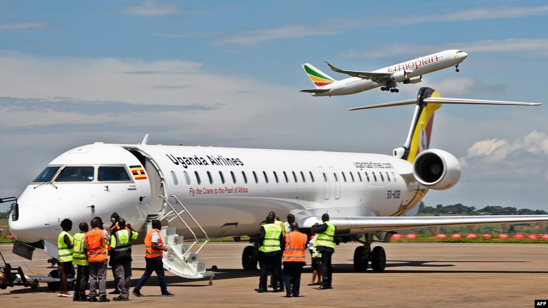 Abakozi bo ku kibuga cy'Indege cya Entebbe muri Uganda bategurira indege yo mu bwoko bwa Bomberdier gufata ikirere.