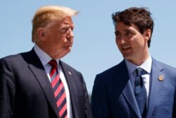 FILE - In this June 8, 2018, file photo, President Donald Trump talks with Canadian Prime Minister Justin Trudeau during a G-7 Summit welcome ceremony in Charlevoix, Canada.