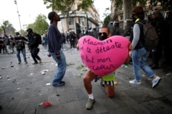 A demonstrator holds a heart reading, "Macron, I hate you with all my heart," during a protest against police brutality and the death in Minneapolis police custody of George Floyd, in Paris, France, June 13, 2020.