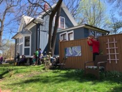 Concert attendees bask in the sunshine while listening to the Milo Trio perform in Takoma Park, Maryland, March 30, 2020. (Julie Taboh/VOA)