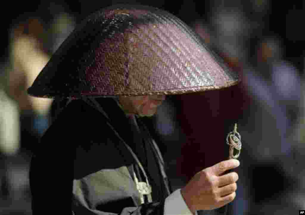 A Buddhist monk prays at Tokyo's Ginza shopping district in Tokyo, Sunday, Feb. 19, 2012.