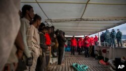 Migrants gather on the deck of the Spanish NGO Proactiva Open Arms rescue vessel after being rescued in the central Mediterranean sea Dec. 21, 2018, before disembarking in the port of Crinavis in Spain, Dec. 28, 2018.