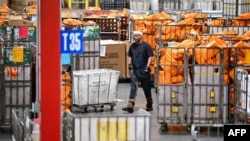 Pegawai Layanan Pos AS (USPS) berjalan di tengah kumpulan paket yang masuk ke area Pusat Pemrosesan dan distribusi Los Angeles, pada 30 November 2022. (Foto: AFP/Frederic J. Brown)