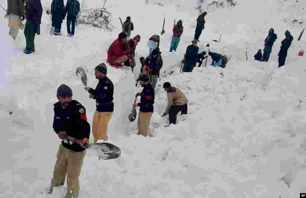 Police officers and local residents dig to search for the bodies of victims of avalanches in Doodnail village in Neelum Valley, Pakistan-administered Kashmir. Search teams aided by Pakistani troops have pulled out 21 bodies from this week&#39;s avalanches.