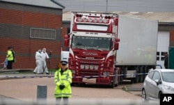 FILE - Police forensics officers attend the scene after a truck was found to contain the bodies of 39 people, in Thurrock, South England, Oct. 23, 2019.