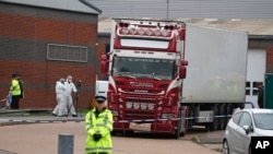 FILE - Police forensics officers attend the scene after a truck was found to contain the bodies of 39 refugees, in Thurrock, South England, Oct. 23, 2019. 