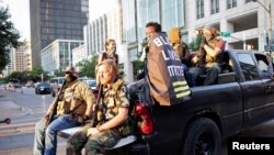 Manifestante de Black Lives Matter Jaborey Burns se pasea con miembros de las Guerrillas de Texas mientras patrullan un mitin de Black Lives Matter en Austin, Texas, EE.UU., 1 de agosto de 2020.