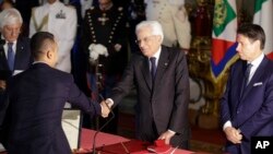 Foreign Minister Luigi Di Maio, left, shakes hands with Italian President Sergio Mattarella, center, as Prime Minister Giuseppe Conte looks on, during a swearing-in ceremony at the Quirinale Presidential Palace, in Rome, Italy, Sept. 5, 2019.