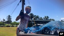 Genshu Price berdiri di belakang truk setelah memuatnya dengan kaleng dan botol daur ulang dari Kualoa Ranch di Kāne'ohe, Hawaii, untuk penggalangan dananya, Bottles4College. (Foto: Bottles4CollegePrice via AP)