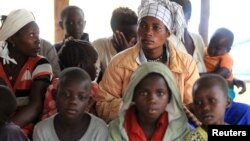 Mothers and children, refugees from from Democratic Republic of Congo, wait to be registered by UNHCR personnel, in Ntoroko, Uganda, Feb. 17, 2018.