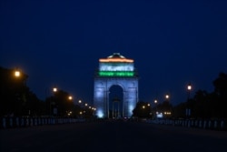 India gate is illuminated with the colors of the Indian national flag as seen from a deserted Rajpath during a government-imposed nationwide lockdown as a preventive measure against the COVID-19 coronavirus in New Delhi on April 8, 2020.