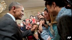 Presiden AS Barack Obama menggoda Sophia Ahmadinejad yang berusia dua tahun, dalam jamuan makan malam untuk merayakan Idul Fitri di Gedung Putih, Washington, DC (21/7). (AP/Pablo Martinez Monsivais)