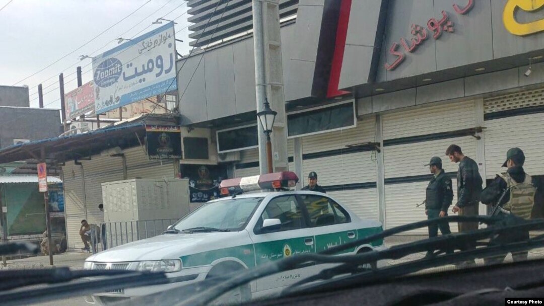 In this photo taken by a Baneh resident, Iranian security forces, including an IRGC officer armed with an Uzi, far right, stage a show of force in Baneh, Iran, as a general strike continues, May 2, 2018. 