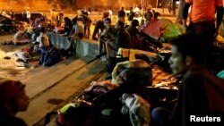 People prepare to sleep in a public square that has become an informal shelter for several hundred undocumented Venezuelan migrants in Bucaramanga, Colombia, Aug. 27, 2018.