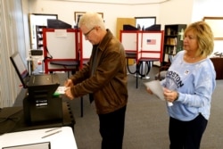 FILE - Greg Froehlinch and his wife Deb of Steubenville, Pa., take advantage of early voting, Sunday, March 15, 2020, in Steubenville, Ohio.