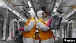 Employees from a disinfection service company sanitize a subway car depot amid coronavirus fears in Seoul, South Korea, March 11, 2020. 