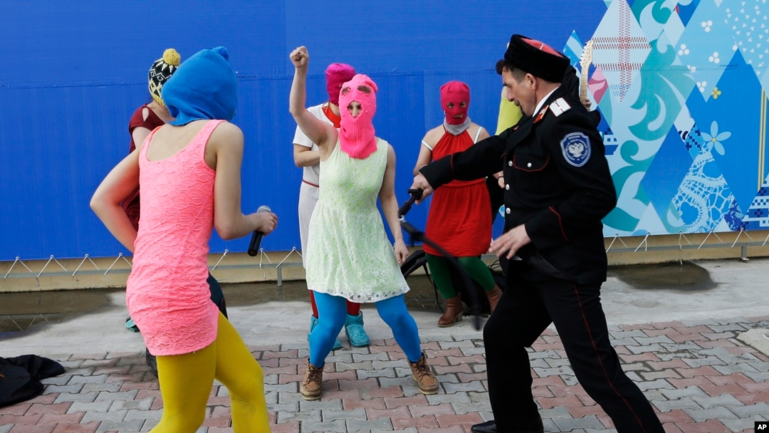 Members of the punk group Pussy Riot, including Nadezhda Tolokonnikova in the blue balaclava and Maria Alekhina in the pink balaclava, are attacked by Cossack militia in Sochi, Russia, on Feb. 19, 2014. 