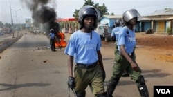 Aparat keamanan Guinea berpatroli di Conakry. Demonstran membakar ban-ban di jalanan, seperti terlihat di latar belakang foto ini.