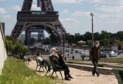 La gente disfruta del sol en el jardín de Trocadero junto a la Torre Eiffel en París, el jueves 14 de mayo de 2020.