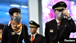 A flight crew arrives from China, after Canada began asking a screening question for visitors and displaying messages in several airports urging travelers to report flulike symptoms, at Vancouver International Airport, British Columbia, Jan. 24, 2020.