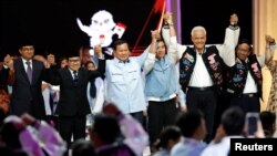 Ketiga pasangan Capres dan Cawapres berpegangan tangan dan berpose bersama usai debat terakhir di Jakarta Convention Center di Jakarta, Minggu malam 4 Februari 2024.