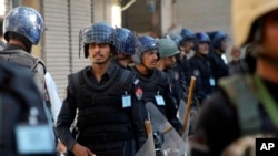 Pakistani police guard a Shi'ite procession during Muharram in Peshawar, Pakistan, Oct. 22, 2015.