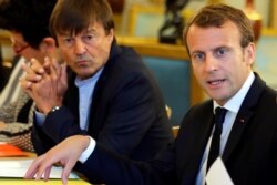 FILE - In this Sept.5, 2017 file photo, French President Emmanuel Macron, right, and Environment Minister Nicolas Hulot meet with NGOs to discuss climate and environment at the Elysee Palace in Paris.