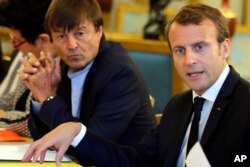 FILE - In this Sept.5, 2017 file photo, French President Emmanuel Macron, right, and Environment Minister Nicolas Hulot meet with NGOs to discuss climate and environment at the Elysee Palace in Paris.