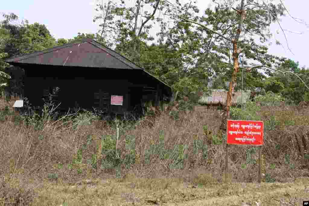 Signs warn relocated villagers not to return to old village or face prosecution according to law, Myitsone, Burma, March 31, 2012. (VOA - D. Schearf)