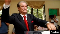 Perdana Menteri Albania dan pemimpin Partai Demokrat Sali Berisha memberikan suara dalam pemilihan umum di Tirana (23/6). (Reuters/Arben Celi)
