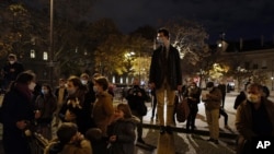 French believers stand and chant religious songs in front of Saint Sulpice Catholic church, in Paris, Nov. 13, 2020.