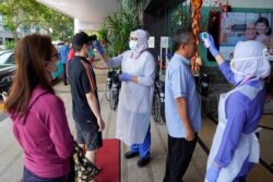 Nurses check the temperatures of visitors as part of the coronavirus screening procedure at a hospital in Kuala Lumpur, Malaysia, Feb. 5, 2020.