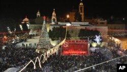 Peziarah dan wisatawan merayakan Natal di Alun-Alun Manger, di luar Gereja Nativity, Bethlehem di Tepi Barat. (AP/Adel Hana)