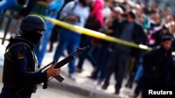 A member of the police special forces stands guard around the scene of a car bomb blast in front of The High Court in downtown Cairo, March 2, 2015. 