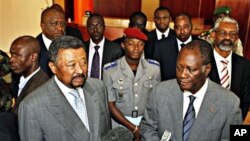 Ivory Coast's internationally-recognized President, Alassane Ouattara, right, stands with African Union Commission Chairman, Jean Ping, left, addressing journalists in Abidjan, March 5, 2011