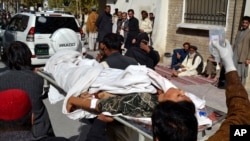 Pakistani volunteers carry a wounded polio worker to a local hospital in Quetta, Pakistan, Nov. 26, 2014. 