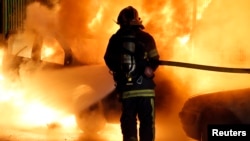 Par petugas pemadam kebakaran memadamkan api dari sebuah mobil yang terbakar pada malam Tahun Baru di Lille, 31 Desember 2013. (Foto:Dok)