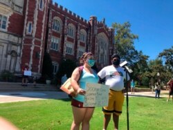 FILE - Kellie Dick, left, a University of Oklahoma senior from Shawnee, and Abhi Nath, a senior from Norman, voice concerns about OU's handling of the coronavirus pandemic during a demonstration, Sept. 3, 2020, in Norman, Okla.