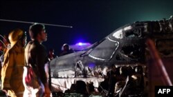 Rescuers stand next to the wreckage of a Westwind aircraft after it caught on fire during takeoff at Manila international airport in Manila on March 29, 2020. 